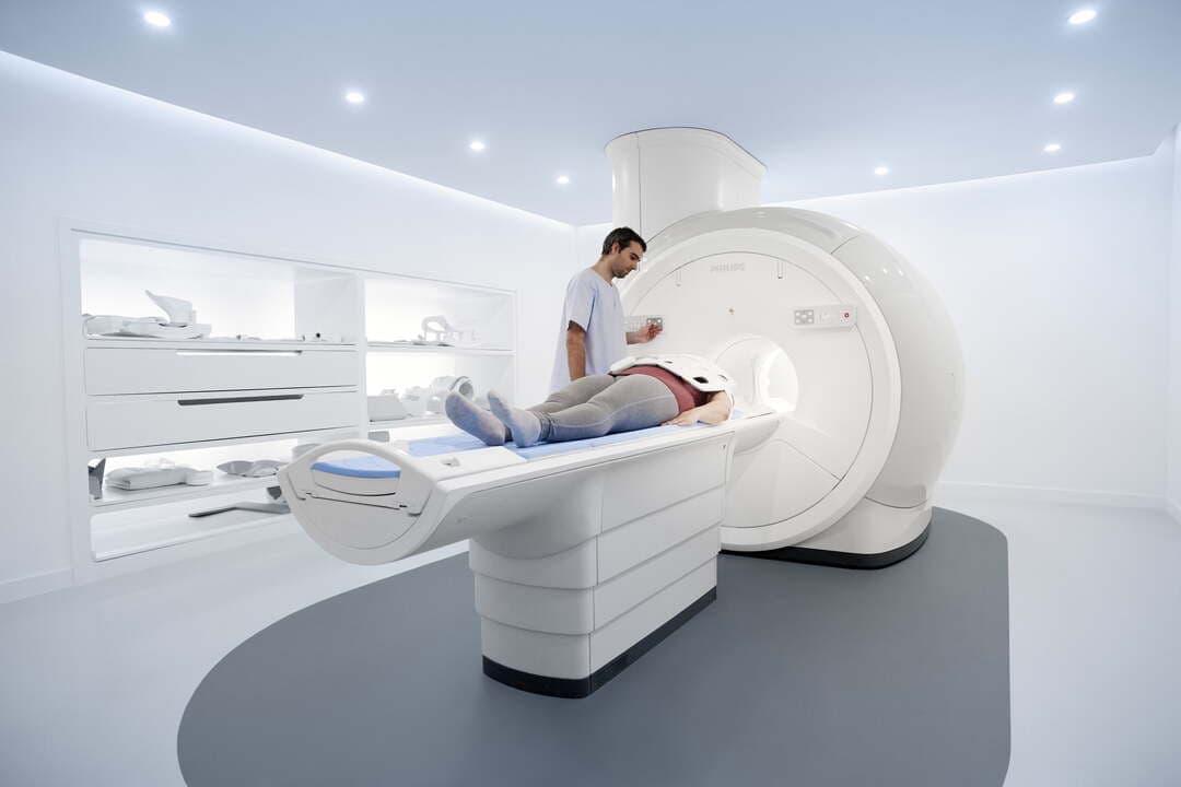 Sala de ressonância magnética com paciente e profissional acompanhando o exame
